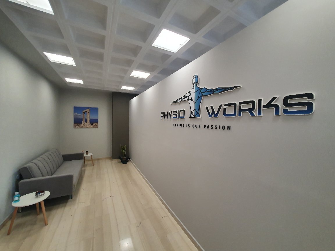 The PHYSIOWORKS reception area with the logo on the wall